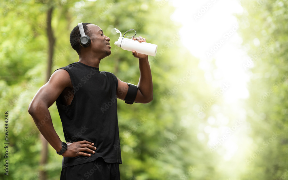 African sportsman drinking water, having break during exercising African sportsman drinking water, having break during exercising
