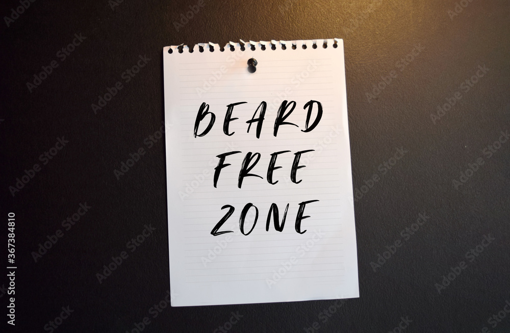 Paper note with BEARD FREE ZONE written on black slate board Paper note with BEARD FREE ZONE written on black slate board