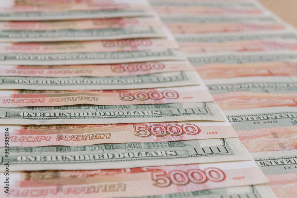 Fototapeta premium A large number of American hundred dollar bills and Russian five thousand dollar bills