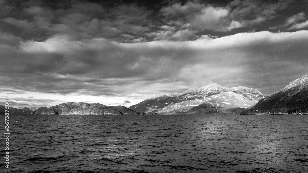 Black and White Photo of the Winter Landscape of Harrison Lake and the surrounding Mountains. Viewed from Harrison Hot Springs in British Columbia, Canada
