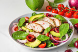 Healthy summer salad with grilled chicken breast, avocado, spinach, cherry berries and tomato. close up