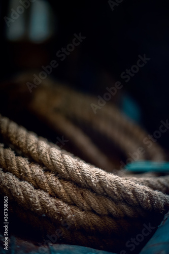Coils of nautical hawser-laid rope in a shed with a dark background