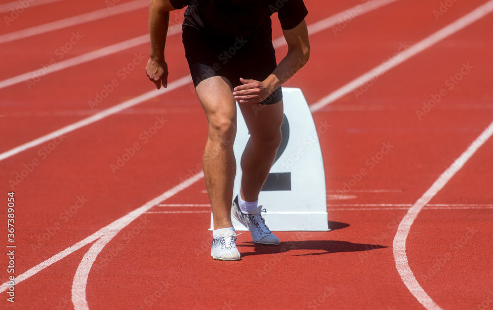 Runner in start position prepares for the start. Individual sport conept Runner in start position prepares for the start. Individual sport conept