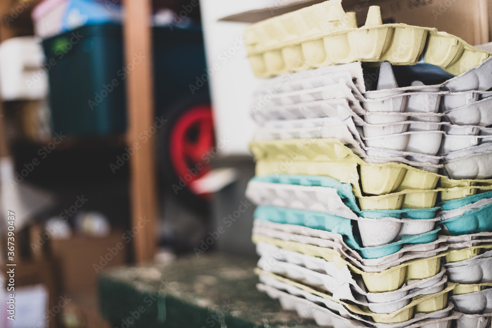 Stacks of multi-coloured cardboard egg cartons in a shed Stacks of multi-coloured cardboard egg cartons in a shed