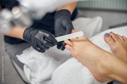 Female having toes nails designed in beauty salon