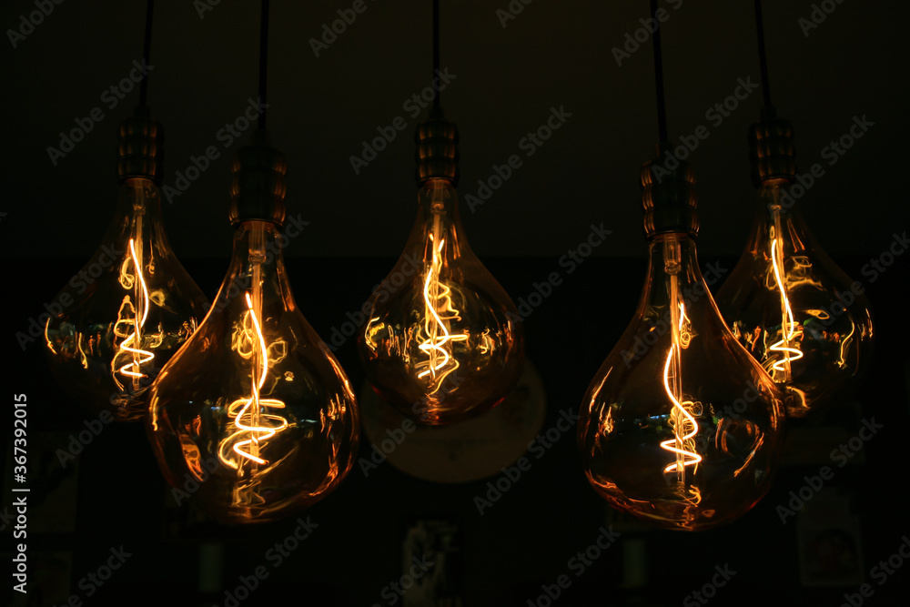 Lighting decor. Retro light bulb filament hanging close up. Illuminated. Lighting decor. Retro light bulb filament hanging close up. Illuminated.