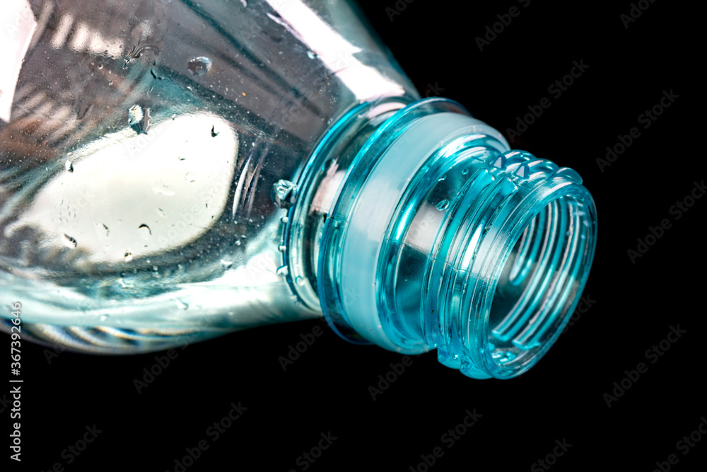 The neck of a plastic bottle. Water storage container. Dark background. The neck of a plastic bottle. Water storage container. Dark background.