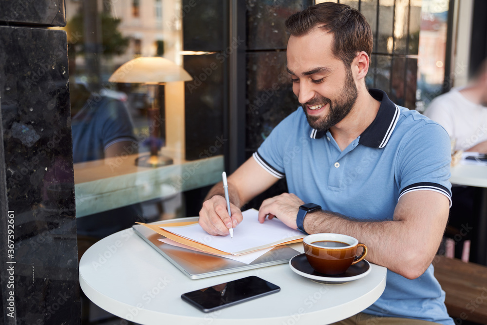 Happy young man with gadgets drinking coffee in cafe Happy young man with gadgets drinking coffee in cafe