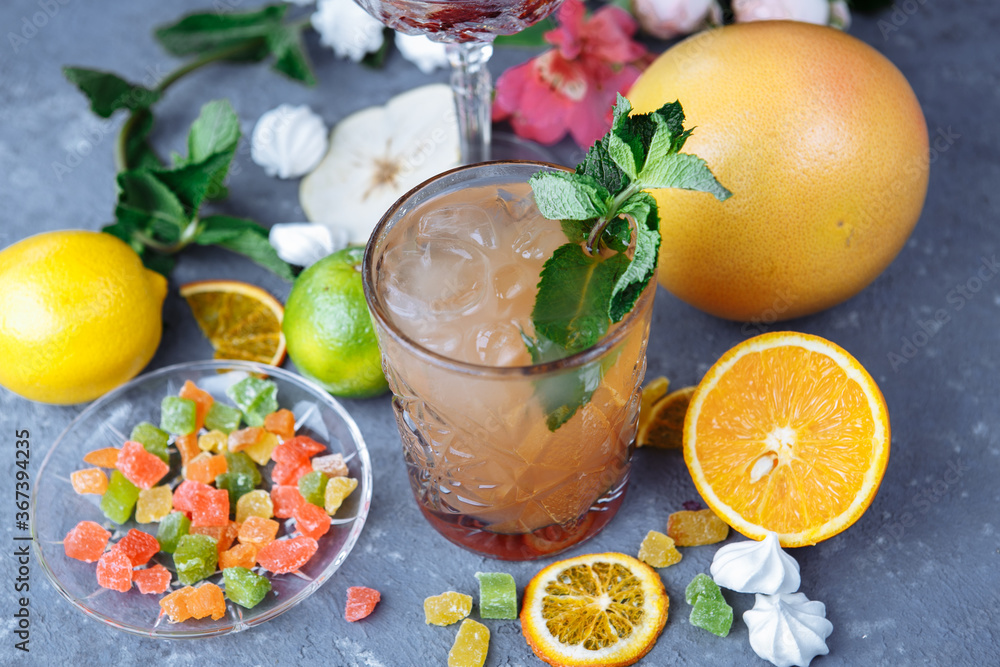Cold refreshing pineapple cocktail with lime and mint for a hot summer day on a gray background decorated with candied fruit, mint and pineapple cubes. mojito idea, homemade lemonade with ice cubes Cold refreshing pineapple cocktail with lime and mint for a hot summer day on a gray background decorated with candied fruit, mint and pineapple cubes. mojito idea, homemade lemonade with ice cubes