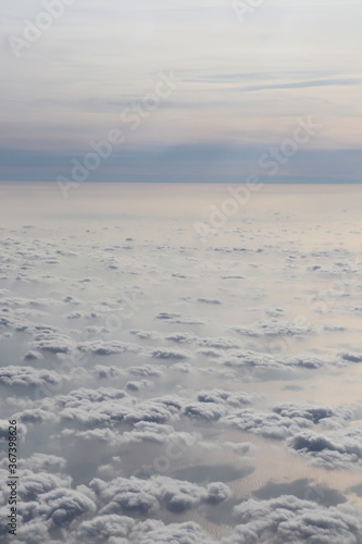 white clouds over the blue ocean, view from the plane window © Serhii Photography