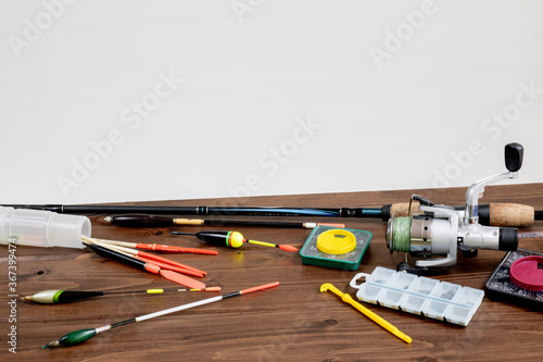 fishing tackle - fishing rod fishing float and accessories on wooden background, copy space.