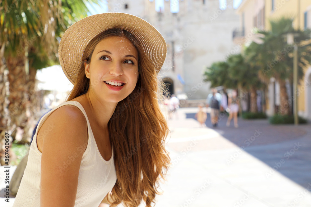 Portrait of young traveler woman visiting Europe. Beautiful tourist girl enjoying her holidays in Sirmione, Italy.
