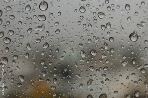 Raindrops on a misted glass with a soft multi-colored background