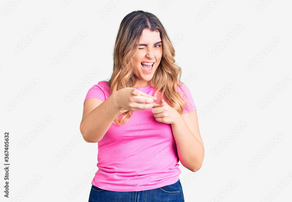 Young caucasian woman wearing sportswear pointing fingers to camera with happy and funny face. good energy and vibes. Young caucasian woman wearing sportswear pointing fingers to camera with happy and funny face. good energy and vibes.