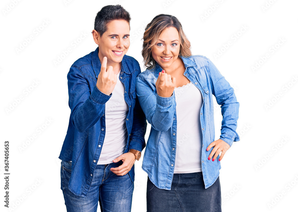 Couple of women wearing casual clothes beckoning come here gesture with hand inviting welcoming happy and smiling