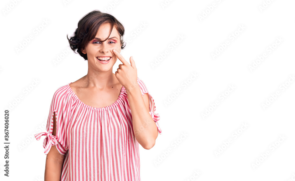 Beautiful young woman with short hair wearing casual summer clothes pointing with hand finger to face and nose, smiling cheerful. beauty concept Beautiful young woman with short hair wearing casual summer clothes pointing with hand finger to face and nose, smiling cheerful. beauty concept