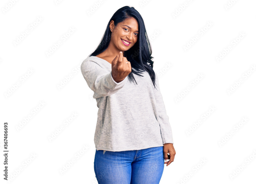 Hispanic woman with long hair wearing casual clothes beckoning come here gesture with hand inviting welcoming happy and smiling Hispanic woman with long hair wearing casual clothes beckoning come here gesture with hand inviting welcoming happy and smiling