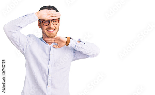 Handsome young man with bear wearing elegant business shirt and glasses smiling cheerful playing peek a boo with hands showing face. surprised and exited