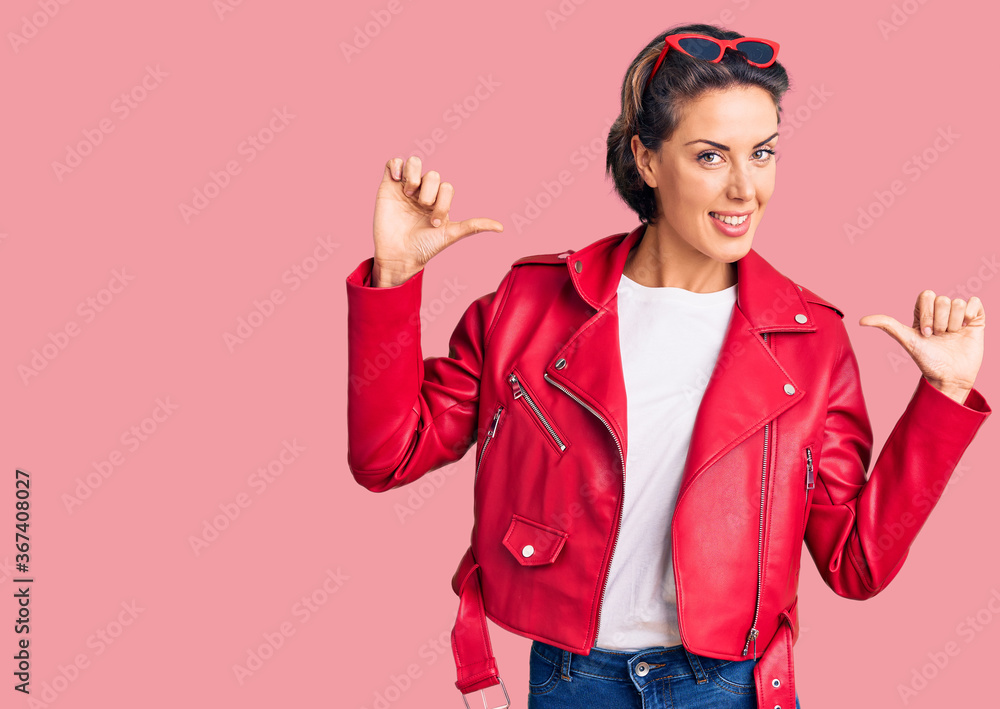 Young beautiful woman wearing red leather jacket looking confident with smile on face, pointing oneself with fingers proud and happy. Young beautiful woman wearing red leather jacket looking confident with smile on face, pointing oneself with fingers proud and happy.