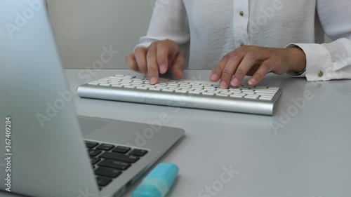 Businesswoman typing on the computer keyboard. Closeup.
