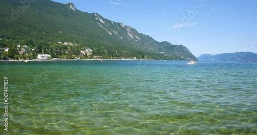 The clear water of Lac du Bourget Lac Gris or Lac d'Aix with clear blue sky and distant sport sailor - French environment protection deepest lake in France