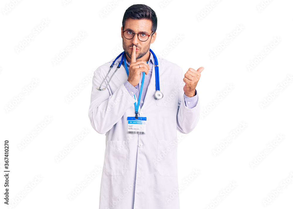 Young hispanic man wearing doctor uniform and stethoscope asking to be quiet with finger on lips pointing with hand to the side. silence and secret concept. Young hispanic man wearing doctor uniform and stethoscope asking to be quiet with finger on lips pointing with hand to the side. silence and secret concept.
