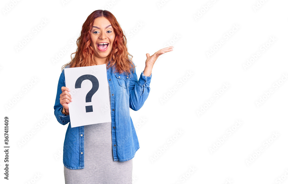 Young latin woman holding question mark celebrating victory with happy smile and winner expression with raised hands Young latin woman holding question mark celebrating victory with happy smile and winner expression with raised hands