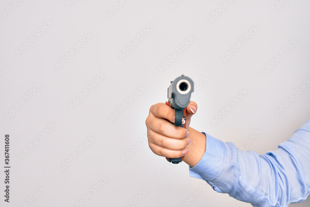 Hand of caucasian young woman holding gun over isolated white background Hand of caucasian young woman holding gun over isolated white background