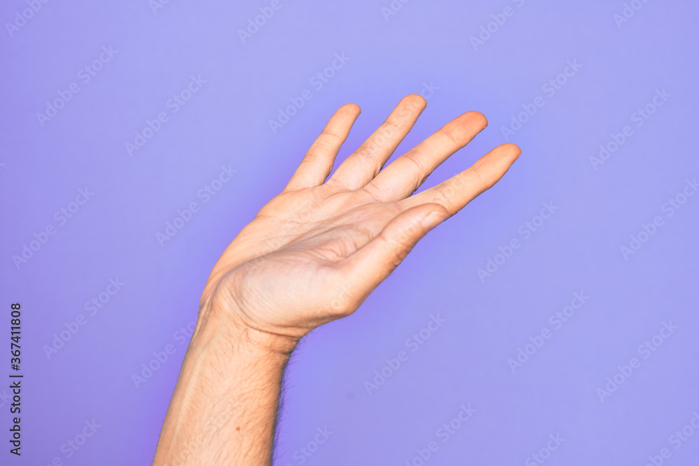 Hand of caucasian young man showing fingers over isolated purple background presenting with open palm, reaching for support and help, assistance gesture