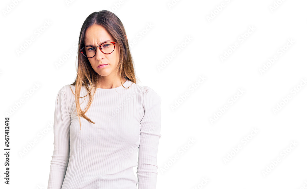 Beautiful brunette young woman wearing casual white sweater and glasses skeptic and nervous, frowning upset because of problem. negative person. Beautiful brunette young woman wearing casual white sweater and glasses skeptic and nervous, frowning upset because of problem. negative person.