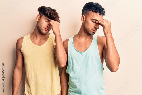 Young gay couple wearing casual clothes tired rubbing nose and eyes feeling fatigue and headache. stress and frustration concept.