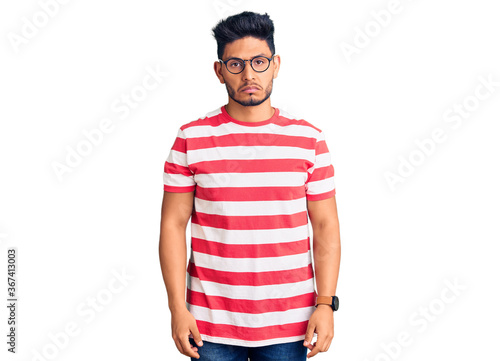 Handsome latin american young man wearing casual clothes and glasses depressed and worry for distress, crying angry and afraid. sad expression.