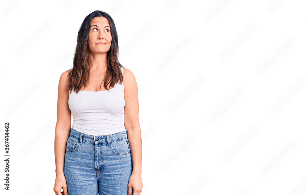 Young beautiful brunette woman wearing casual sleeveless t-shirt smiling looking to the side and staring away thinking. Young beautiful brunette woman wearing casual sleeveless t-shirt smiling looking to the side and staring away thinking.