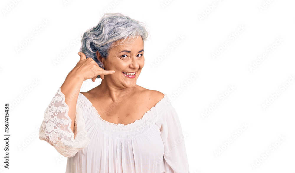 Senior woman with gray hair wearing bohemian style smiling doing phone gesture with hand and fingers like talking on the telephone. communicating concepts. Senior woman with gray hair wearing bohemian style smiling doing phone gesture with hand and fingers like talking on the telephone. communicating concepts.