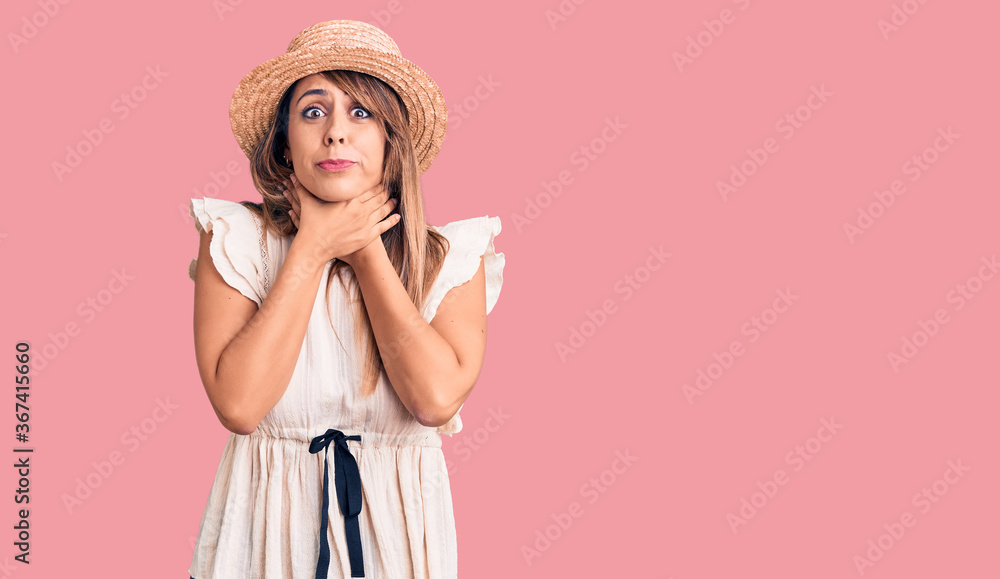 Young beautiful woman wearing summer hat and t-shirt shouting and suffocate because painful strangle. health problem. asphyxiate and suicide concept. Young beautiful woman wearing summer hat and t-shirt shouting and suffocate because painful strangle. health problem. asphyxiate and suicide concept.