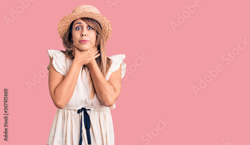 Young beautiful woman wearing summer hat and t-shirt shouting and suffocate because painful strangle. health problem. asphyxiate and suicide concept.