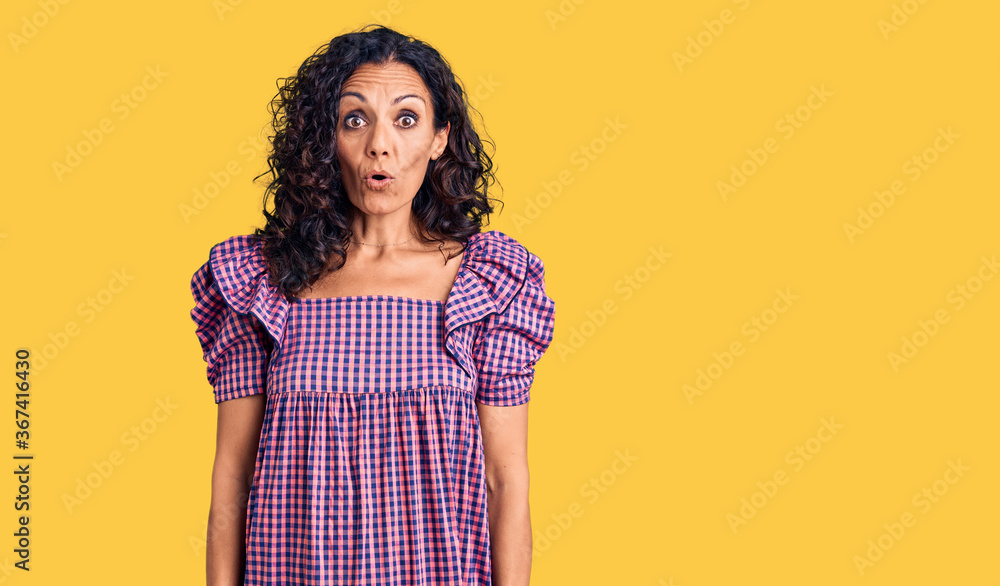 Obraz premium Middle age beautiful woman wearing casual dress scared and amazed with open mouth for surprise, disbelief face