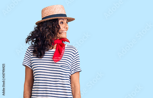 Middle age beautiful woman wearing casual striped t shirt and summer hat looking away to side with smile on face, natural expression. laughing confident. © Krakenimages.com