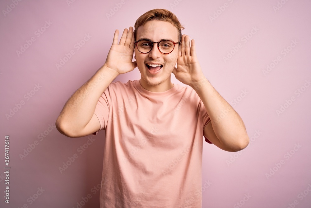 Young handsome redhead man wearing casual t-shirt standing over isolated pink background Smiling cheerful playing peek a boo with hands showing face. Surprised and exited Young handsome redhead man wearing casual t-shirt standing over isolated pink background Smiling cheerful playing peek a boo with hands showing face. Surprised and exited
