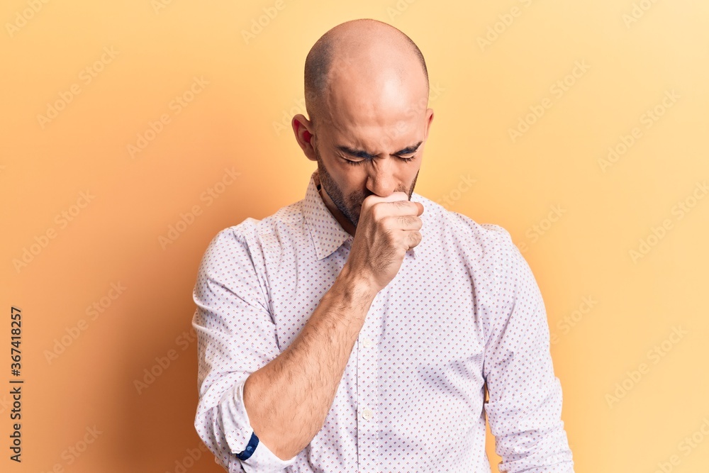 Young handsome bald man wearing elegant shirt feeling unwell and coughing as symptom for cold or bronchitis. health care concept. Young handsome bald man wearing elegant shirt feeling unwell and coughing as symptom for cold or bronchitis. health care concept.