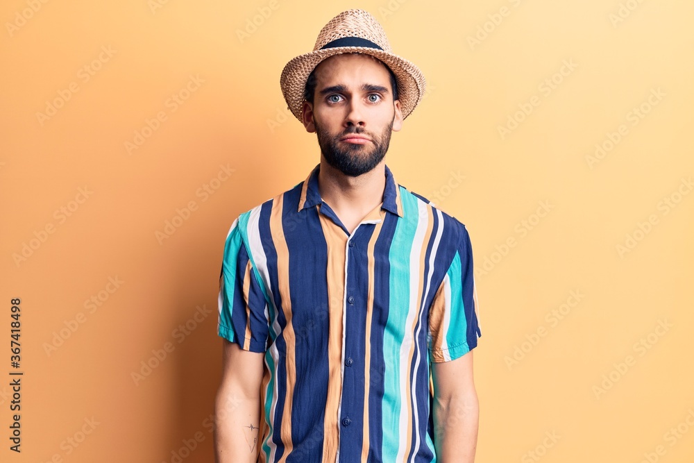 Young handsome man with beard wearing summer hat and shirt depressed and worry for distress, crying angry and afraid. sad expression. Young handsome man with beard wearing summer hat and shirt depressed and worry for distress, crying angry and afraid. sad expression.