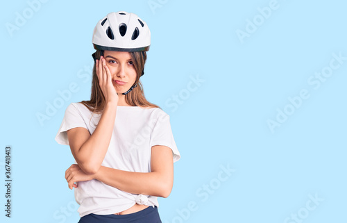 Young beautiful girl wearing bike helmet thinking looking tired and bored with depression problems with crossed arms. © Krakenimages.com