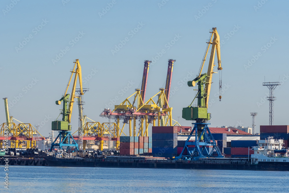 Sea commercial port. Loading and unloading operations in the port. Cranes and cargo containers on the shore. Merchant fleet. Shipping.