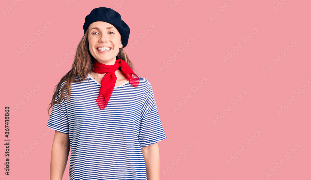 Young beautiful blonde woman wearing french beret and striped t-shirt with a happy and cool smile on face. lucky person. Young beautiful blonde woman wearing french beret and striped t-shirt with a happy and cool smile on face. lucky person.