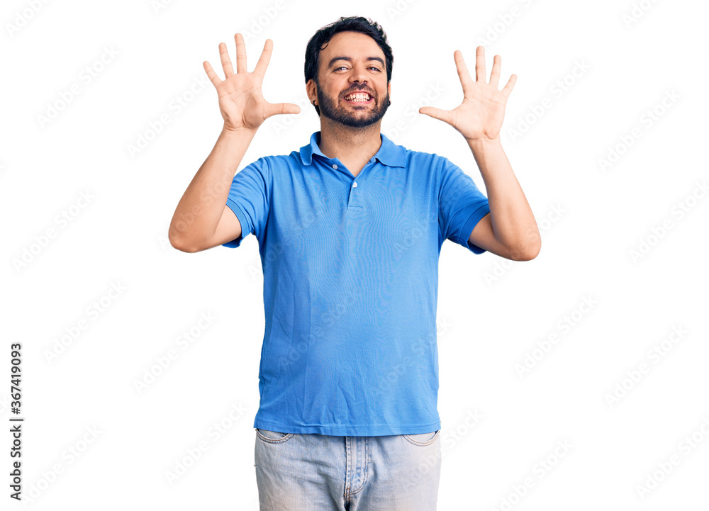 Young hispanic man wearing casual clothes showing and pointing up with fingers number ten while smiling confident and happy. Young hispanic man wearing casual clothes showing and pointing up with fingers number ten while smiling confident and happy.