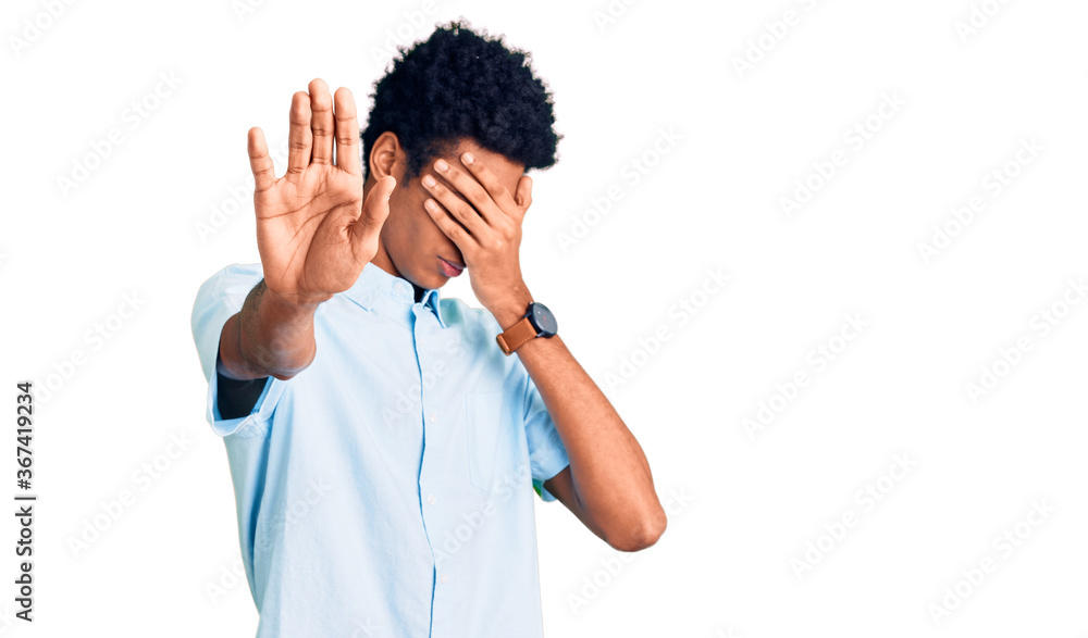 Young african american man wearing casual clothes covering eyes with hands and doing stop gesture with sad and fear expression. embarrassed and negative concept. Young african american man wearing casual clothes covering eyes with hands and doing stop gesture with sad and fear expression. embarrassed and negative concept.