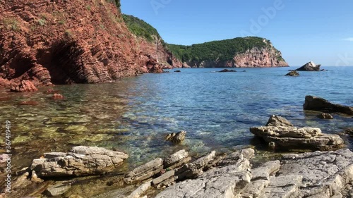 Wild turquoise sea bay, cliffs and red rocks. Crvena Glavica, Montenegro 