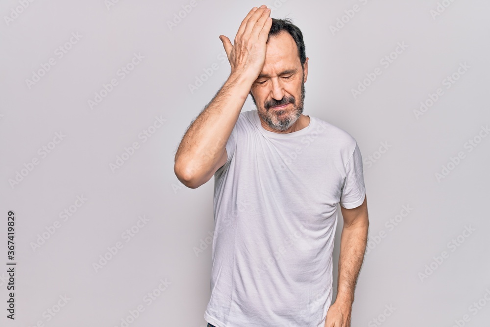 Middle age handsome man wearing casual t-shirt standing over isolated white background surprised with hand on head for mistake, remember error. Forgot, bad memory concept. Middle age handsome man wearing casual t-shirt standing over isolated white background surprised with hand on head for mistake, remember error. Forgot, bad memory concept.