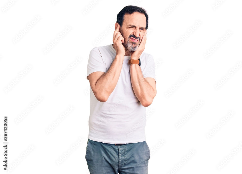 Middle age handsome man wearing casual t-shirt covering ears with fingers with annoyed expression for the noise of loud music. deaf concept. Middle age handsome man wearing casual t-shirt covering ears with fingers with annoyed expression for the noise of loud music. deaf concept.