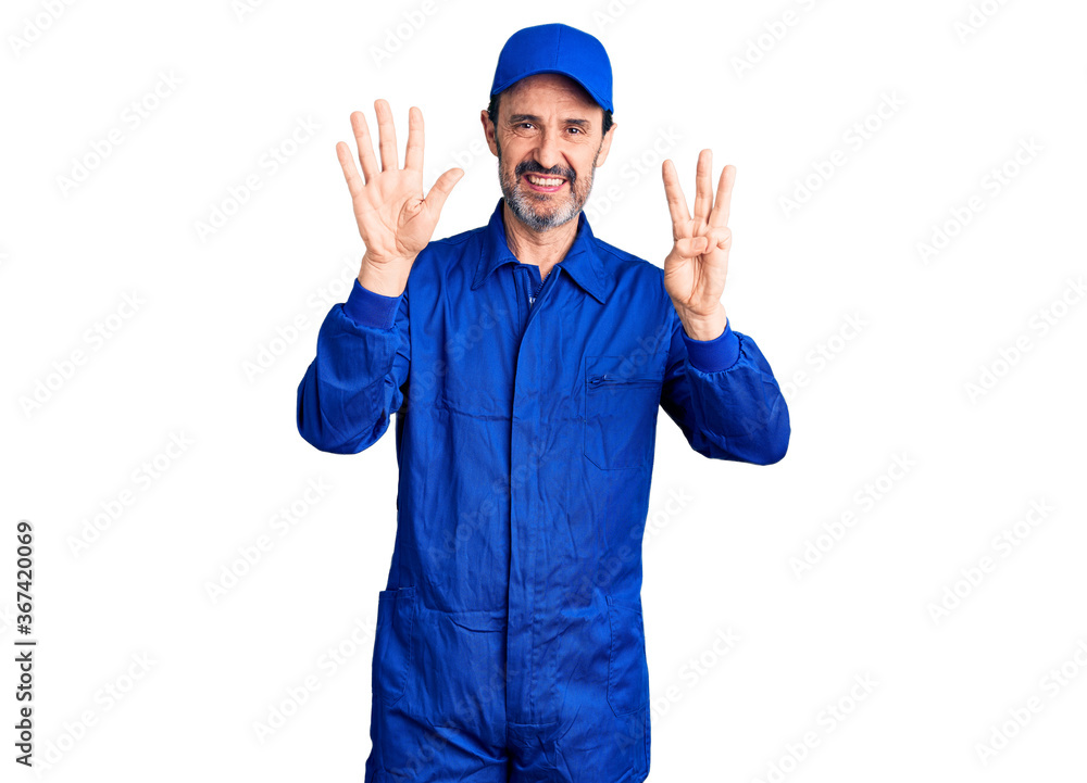 Middle age handsome man wearing mechanic uniform showing and pointing up with fingers number eight while smiling confident and happy. Middle age handsome man wearing mechanic uniform showing and pointing up with fingers number eight while smiling confident and happy.